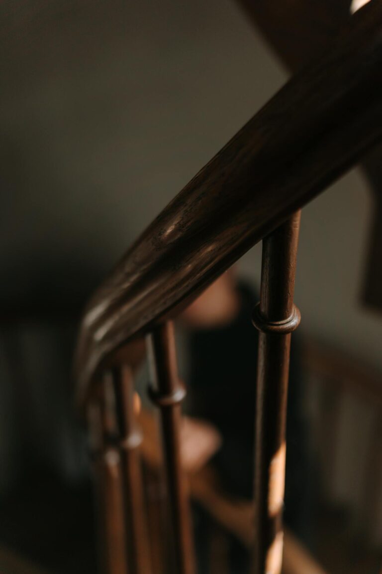 Close-up of a vintage wooden handrail and staircase, capturing a soft focus and warm mood.